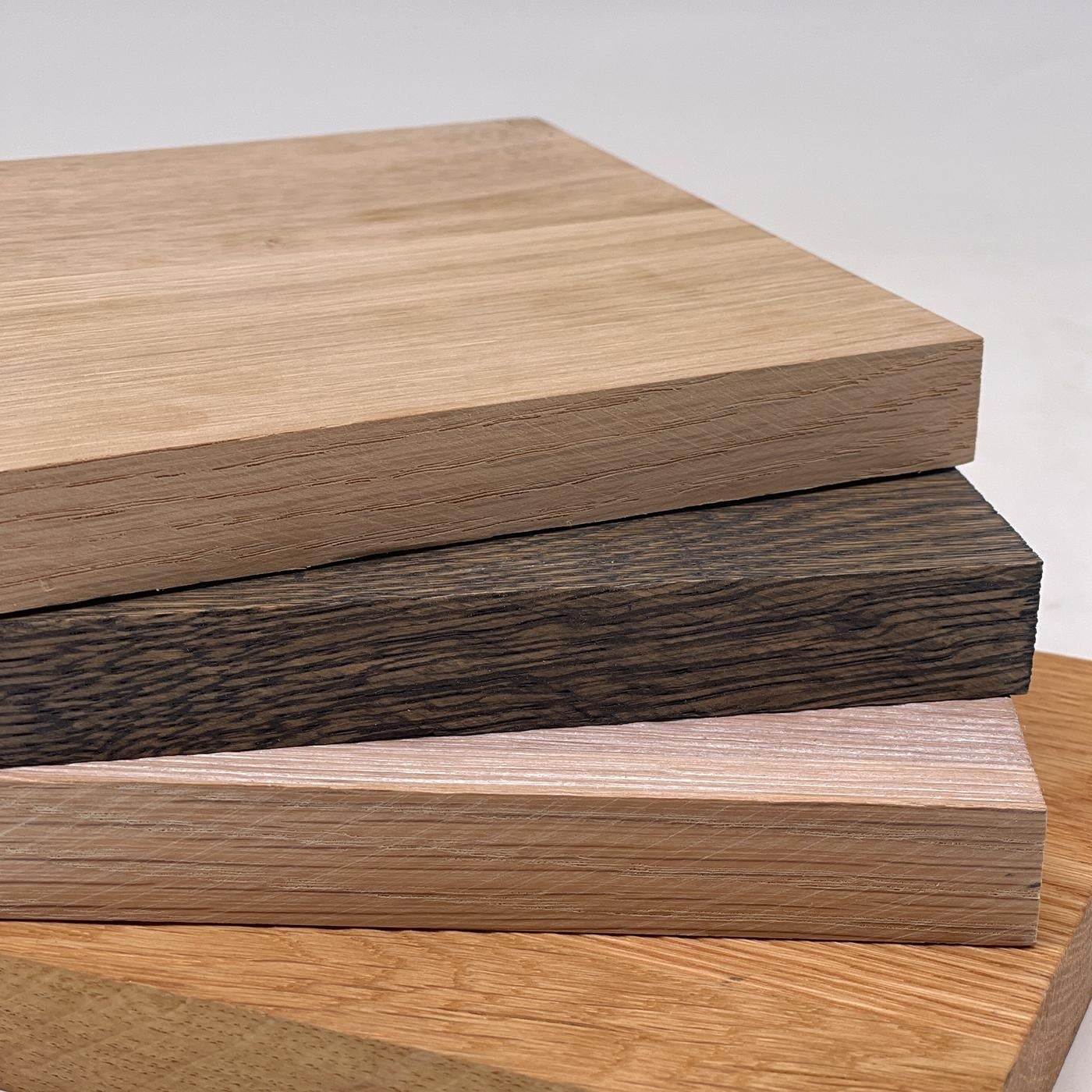 Vier Holzplatten liegen in verschiedenen Farbtönen geordnet übereinander.
