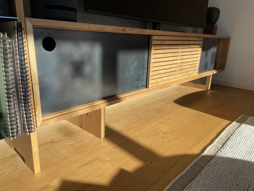 Ein niedriges Sideboard aus Holz zeigt dunkle Fronten im warmen Sonnenlicht.