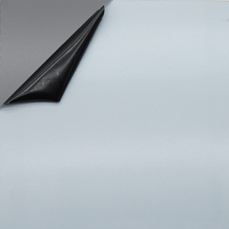 Schwarze Schutzfolie wird von glatter Aluminiumoberfläche abgezogen.