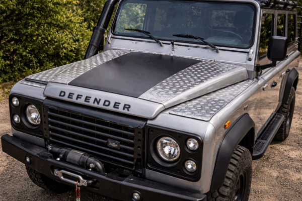 Land Rover Defender mit Aluriffelblech-Akzenten auf der Motorhaube.