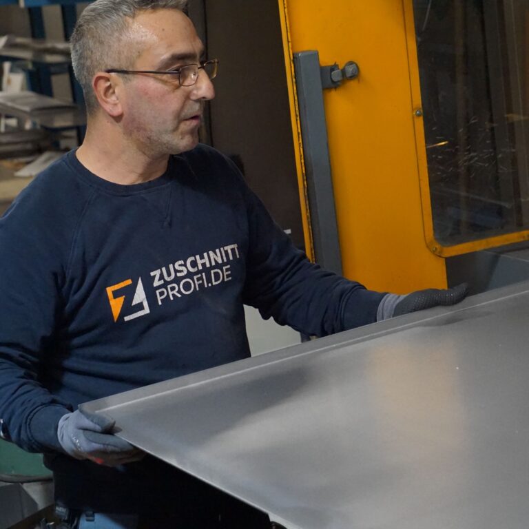 Mitarbeiter fertigt Edelstahlplatte bei zuschnittprofi.mom.