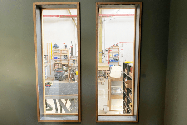 Zwei Fenster geben den Blick in eine Werkstatt frei.