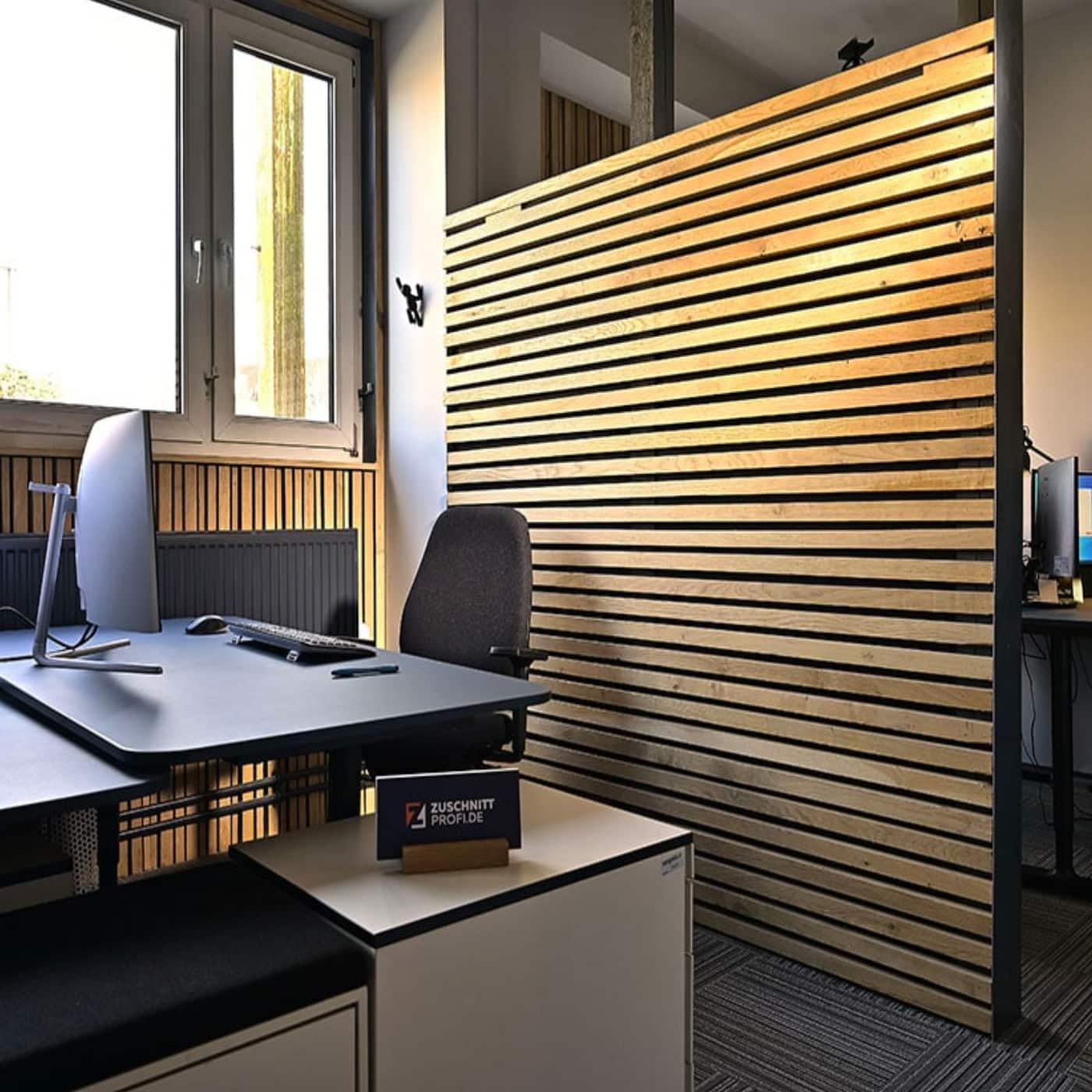 Ein Büro zeigt eine Wandverkleidung aus horizontalen Holzleisten im Innenraum.