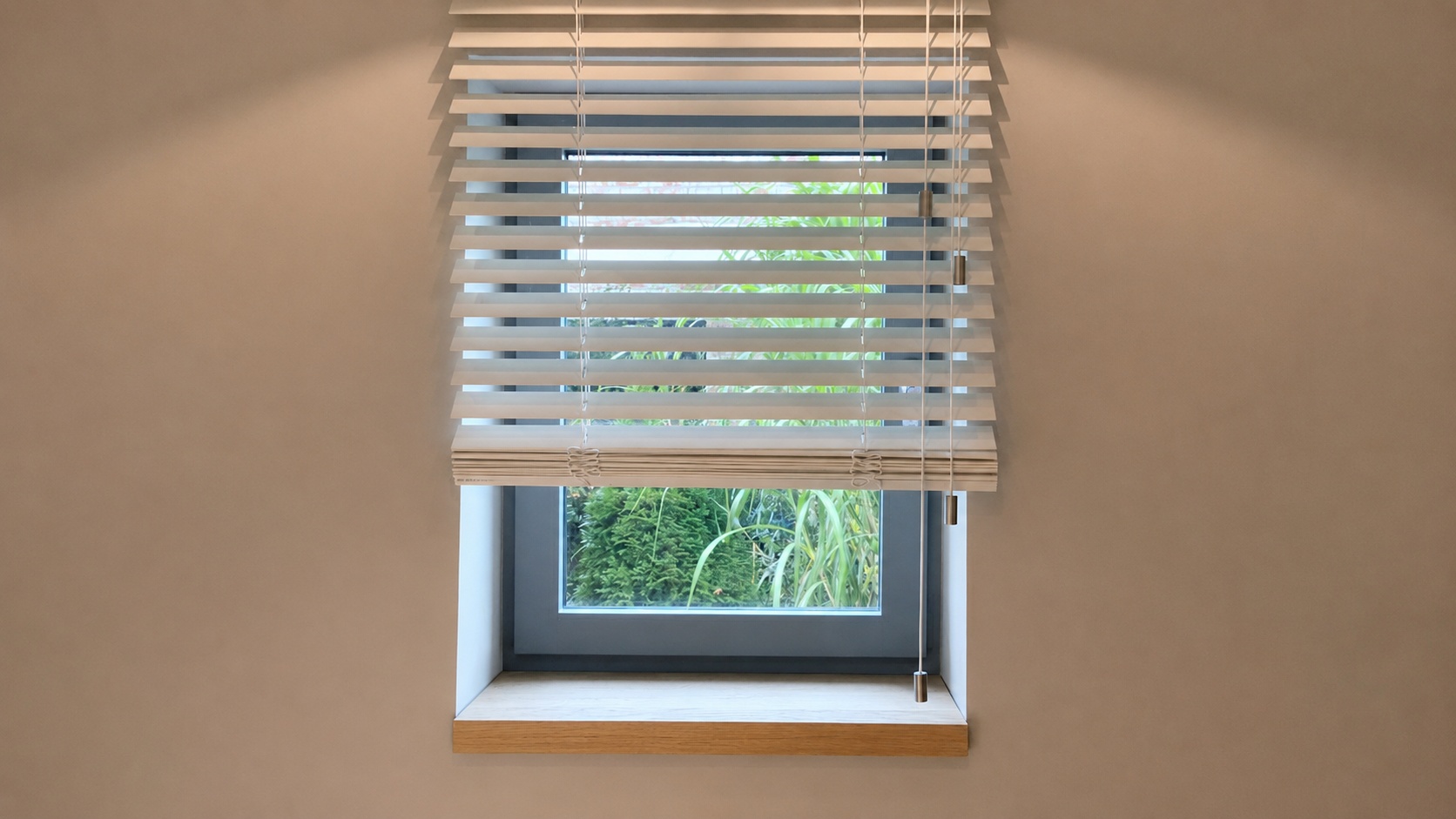 Eine Fensterbank aus Eiche befindet sich unter einem Fenster mit weißen Jalousien.