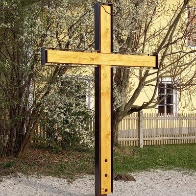 Ein großes Holzflurkreuz steht im Freien.