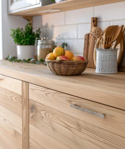 Eine helle Küchenfront aus Eschenholz zeigt Obst und Küchenutensilien auf der Arbeitsplatte.