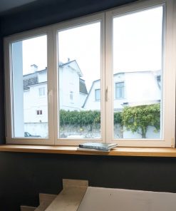 Helle Fensterbank aus Holz mit Büchern vor weißem Fenster.