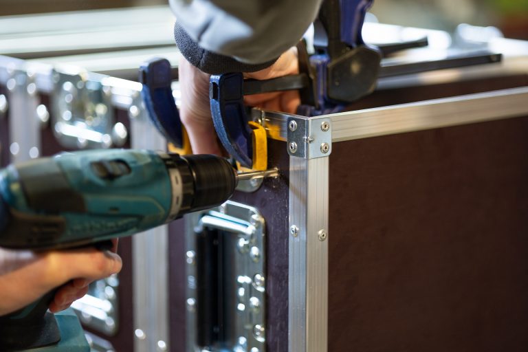 Arbeiter stellt in der Werkstatt Flightcases her.