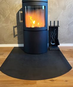 Eine halbrunde Funkenschutzplatte bietet sicheren Schutz vor dem Kamin und wirkt zugleich harmonisch im Raum.
