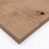 Eine massive Eichenbohle zeigt eine natürliche Holzmaserung mit markanter Aststelle.