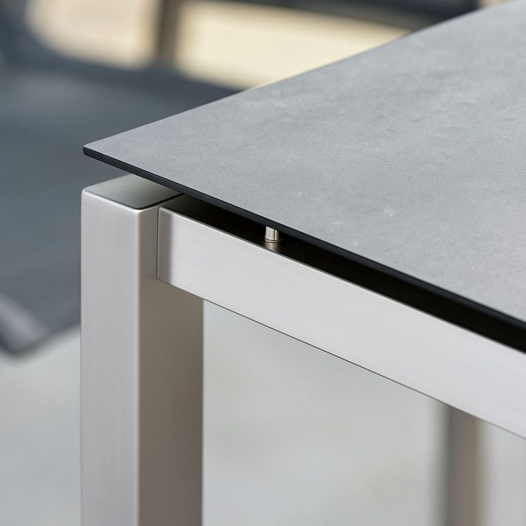 HPL-Platte in Betonoptik auf modernem Metalltischgestell.