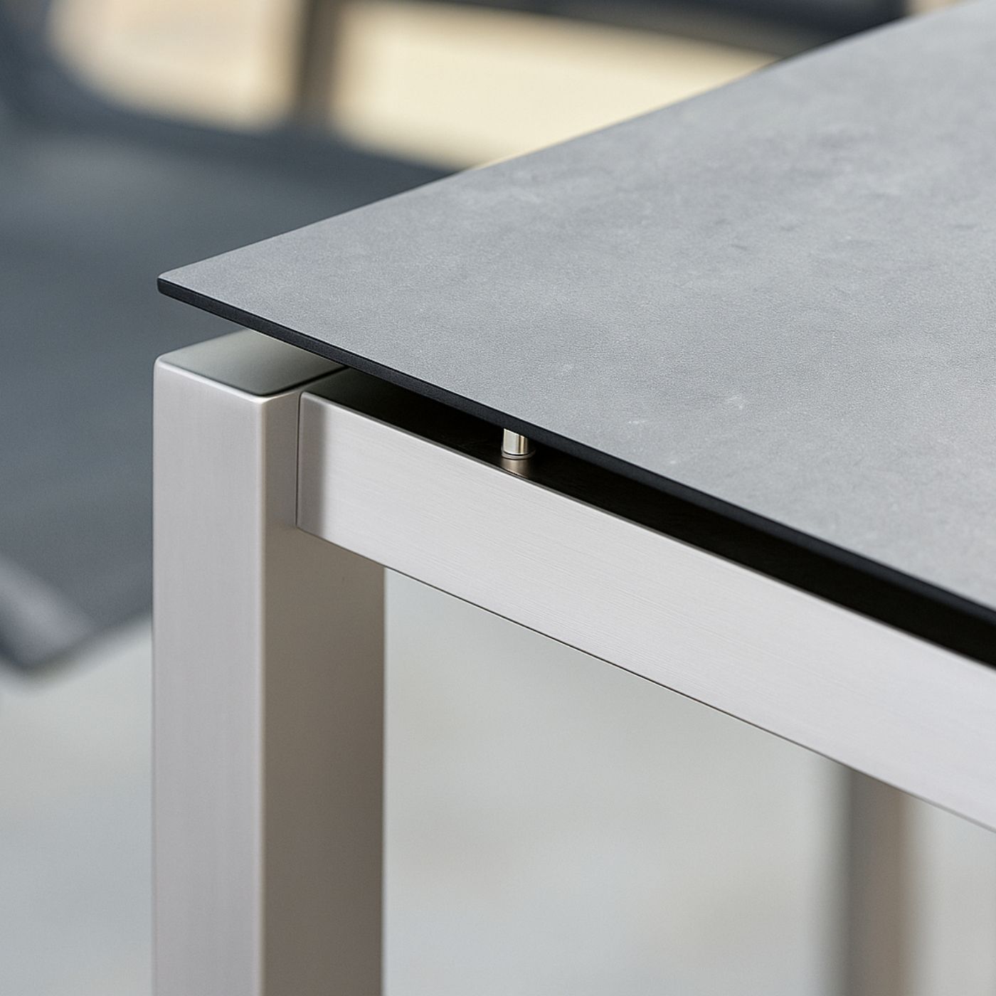 HPL-Platte in Betonoptik auf modernem Metalltischgestell.