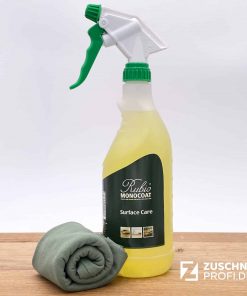 Reinigungsflasche und Tuch zur Holzpflege auf Holzoberfläche.