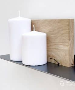 Schmales Wandregal in schwarzem Metall, Holzdeko und weißen Kerzen.