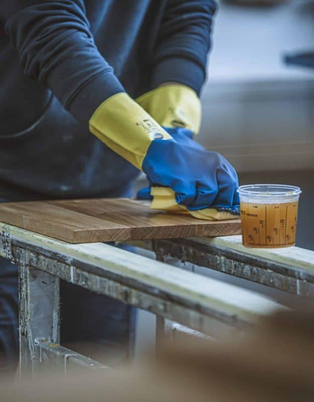 Holzplatte wird in der Werkstatt sorgfältig geölt und poliert.