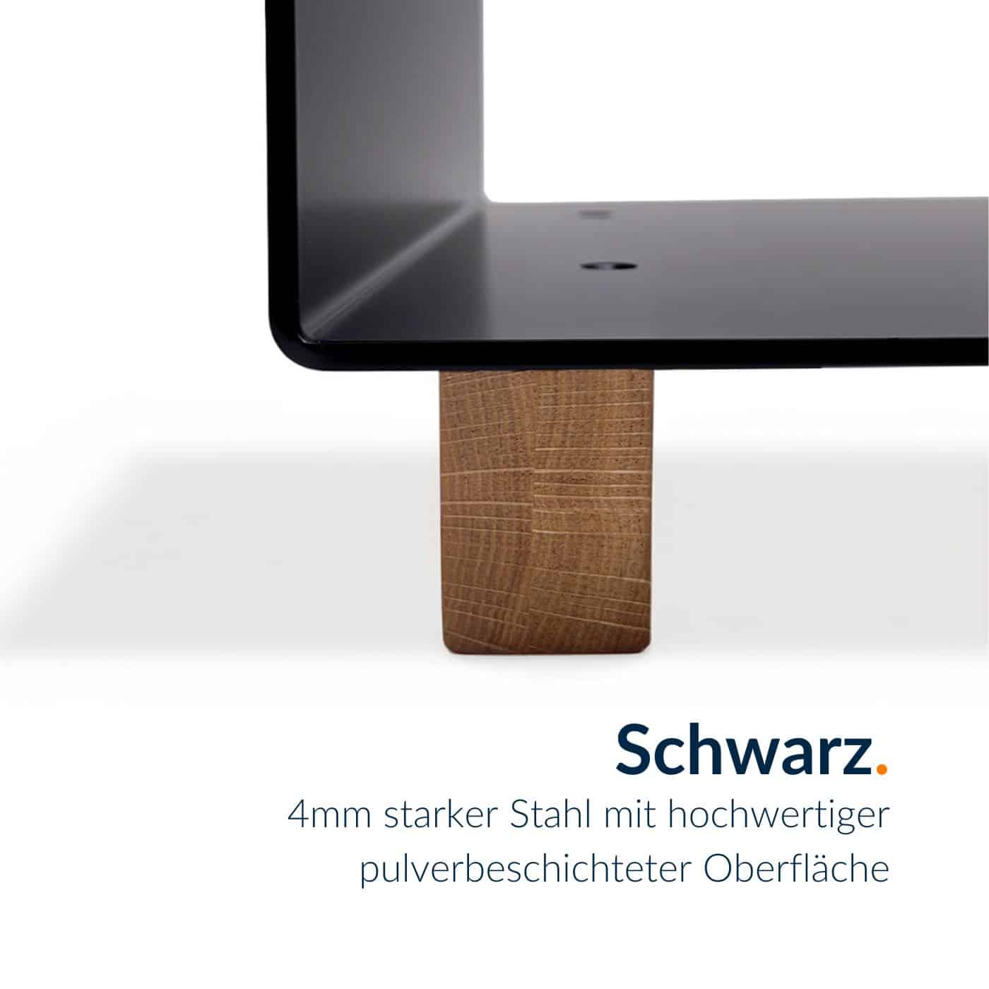 Ein schwarzer Kaminholzständer ruht auf einem massiven Holzblock.