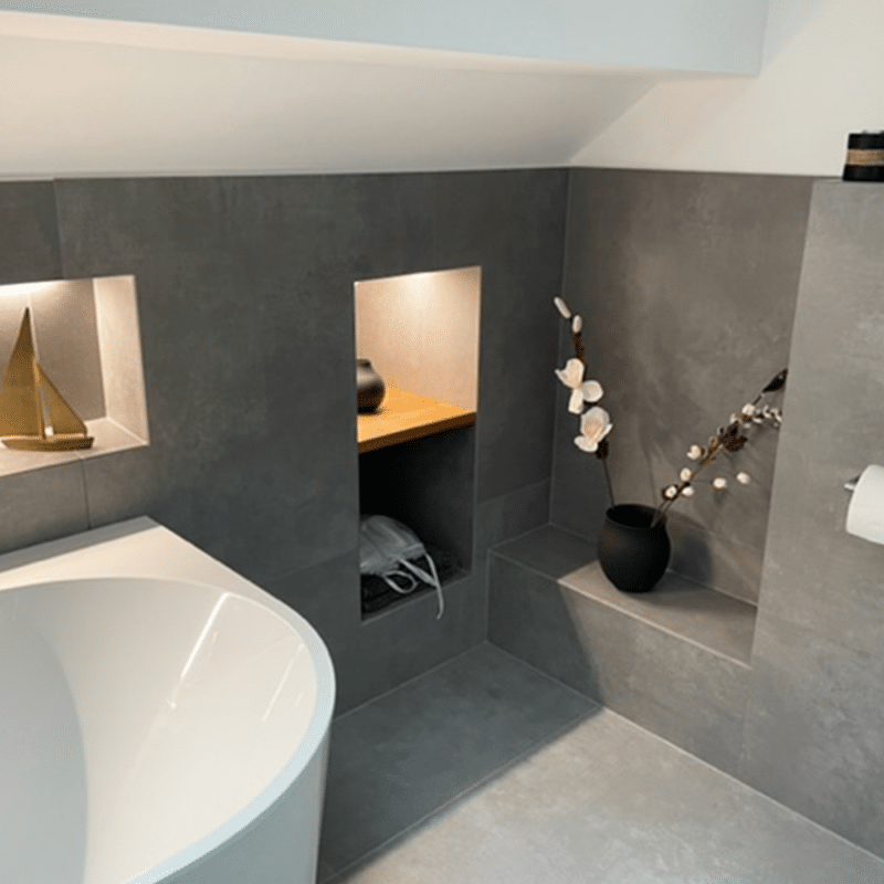 Eine Holzablage ist in eine geflieste Nische im Badezimmer eingelassen.