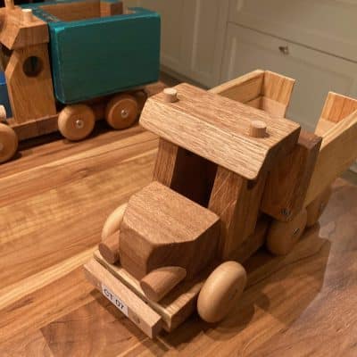 Liebevoll gebaute Holzfahrzeuge stehen fertig montiert und sorgfältig geschliffen auf dem Tisch.