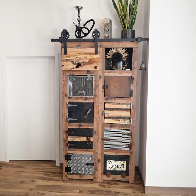 Ein Holzregal zeigt unterschiedliche Metallplatten und dekorative Gegenstände.