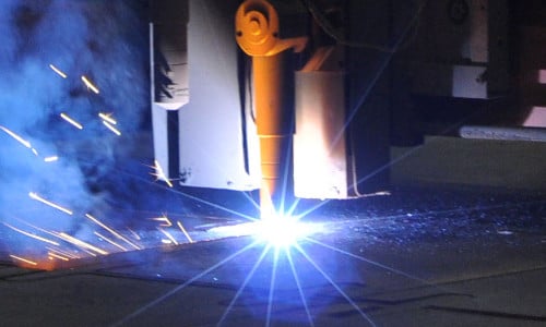 Beim Metallschneiden entstehen helle Funken, die den industriellen Fertigungsprozess verdeutlichen.