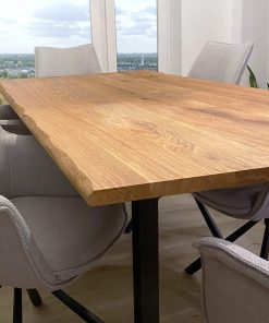 Ein großer Tisch aus Massivholz steht in einem hellen, modernen Essbereich.