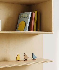Multiplexregal mit Büchern, Holzfiguren und kleiner Pflanze dekoriert.