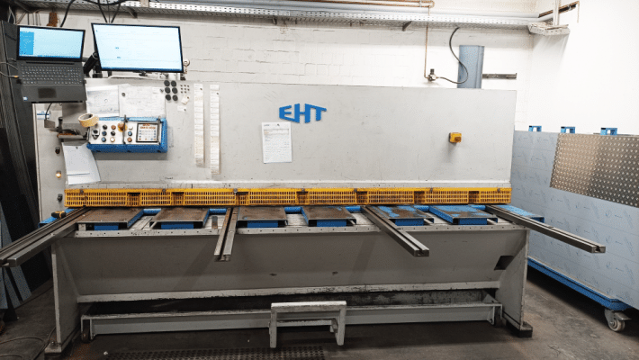 Eine industrielle Schneideanlage steht in einer hellen Produktionshalle.