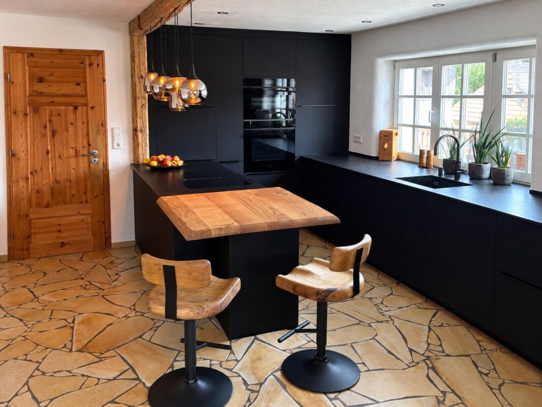 Holztheke an schwarzer Kücheninsel schafft einen Sitzplatz in der modernen Küche.