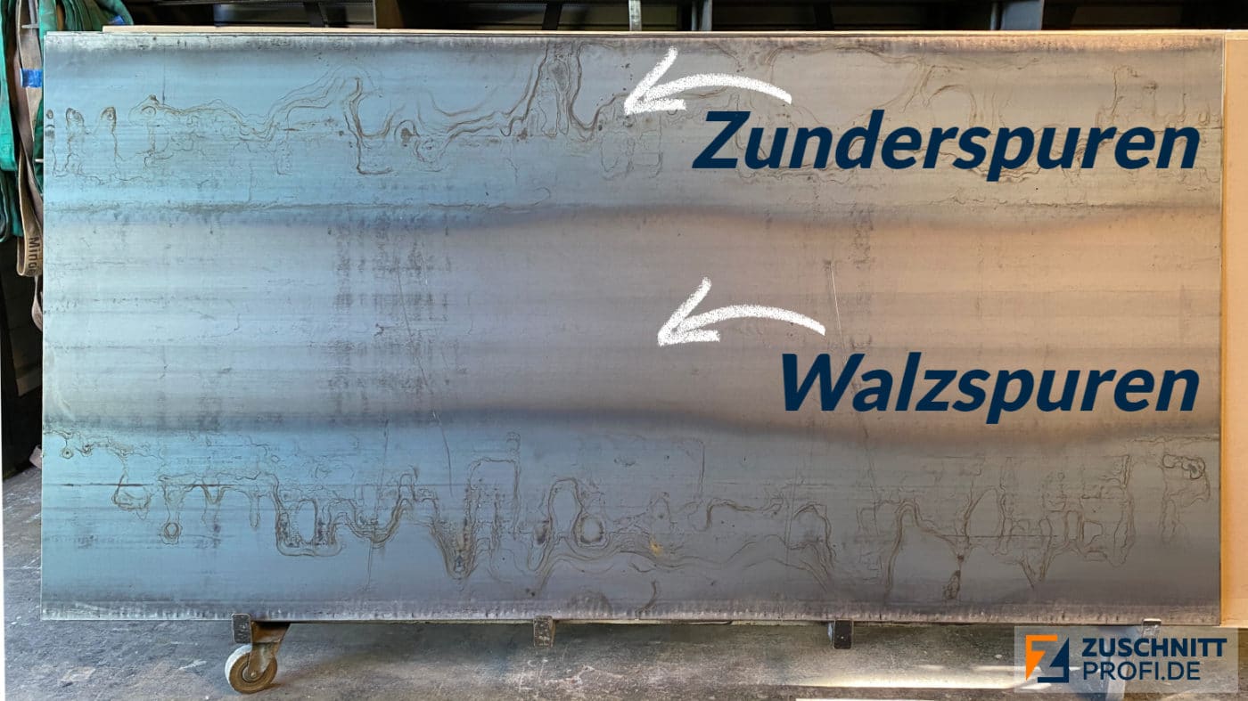 Die große Stahlplatte weist deutliche Zunder- und Walzspuren auf, die sich horizontal über die Fläche ziehen.