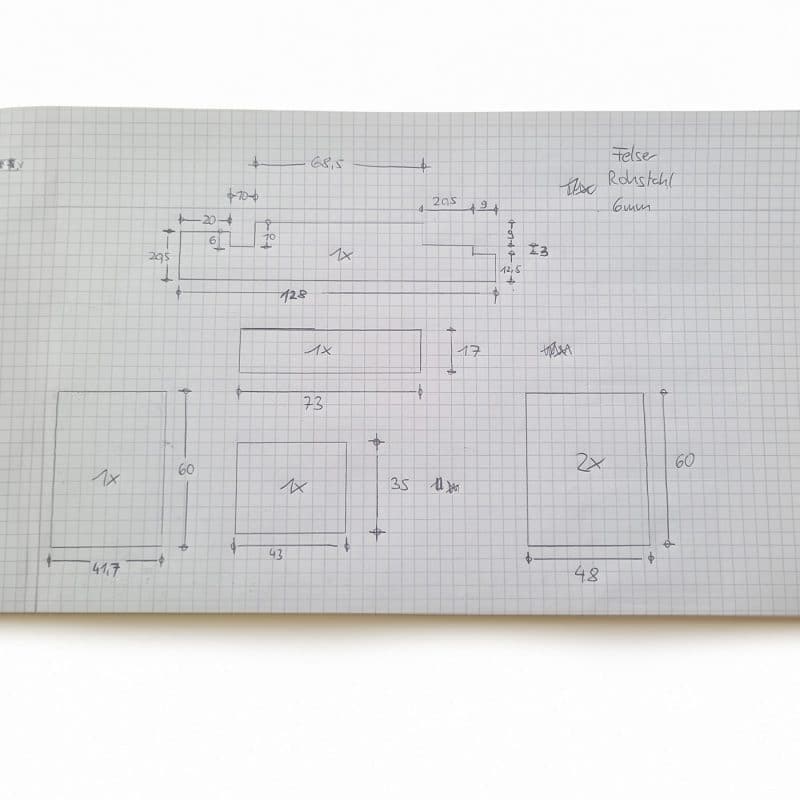 Eine technische Zeichnung zeigt Maße und Skizzen auf kariertem Papier.