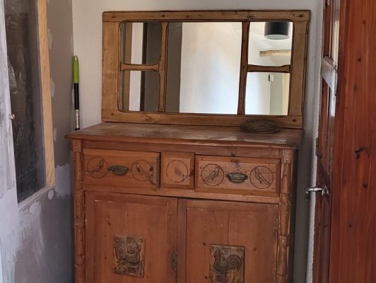 Ein massives Holzbuffet mit Spiegeltüren zeigt seinen rustikalen, handwerklichen Charakter.