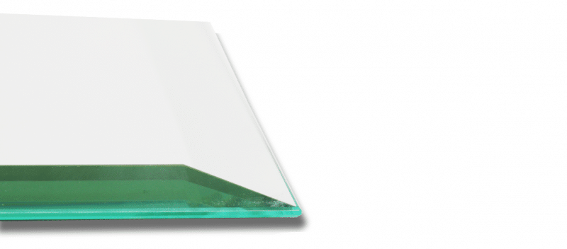 Eine transparente Glasplatte mit grünlicher Kante liegt auf hellem Untergrund.