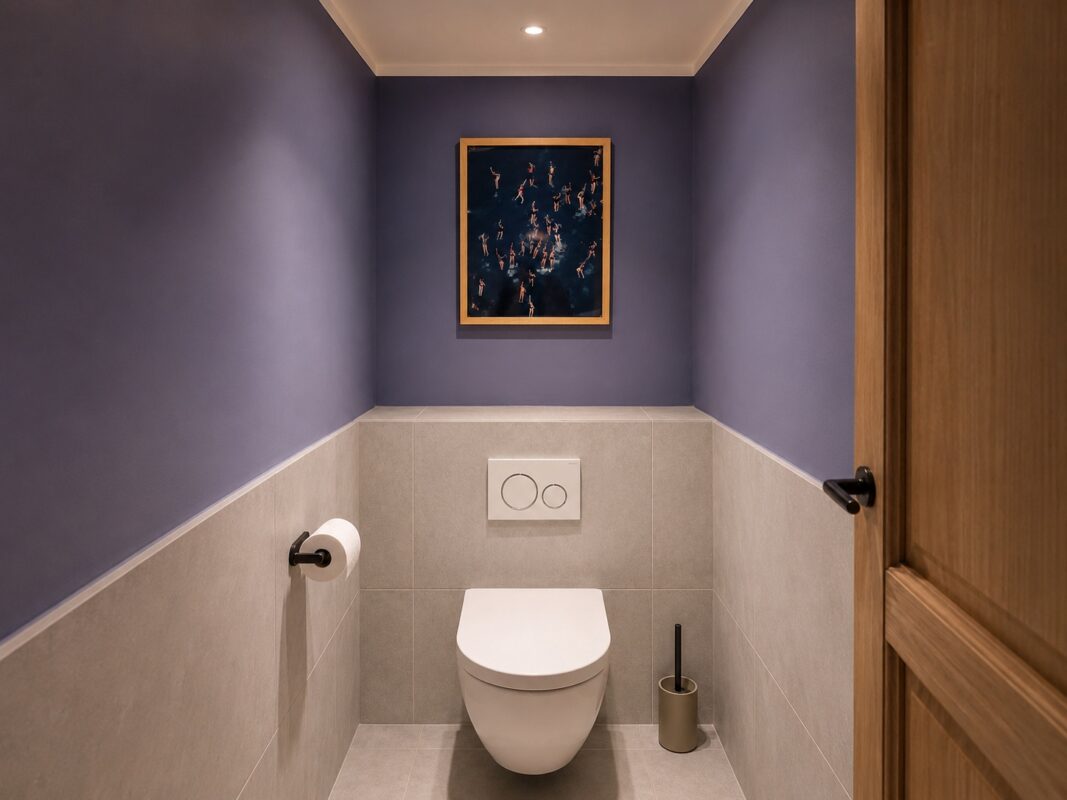 Modernes Gäste-WC mit grauen Fliesen, dunklen Wänden und wandhängender Toilette.