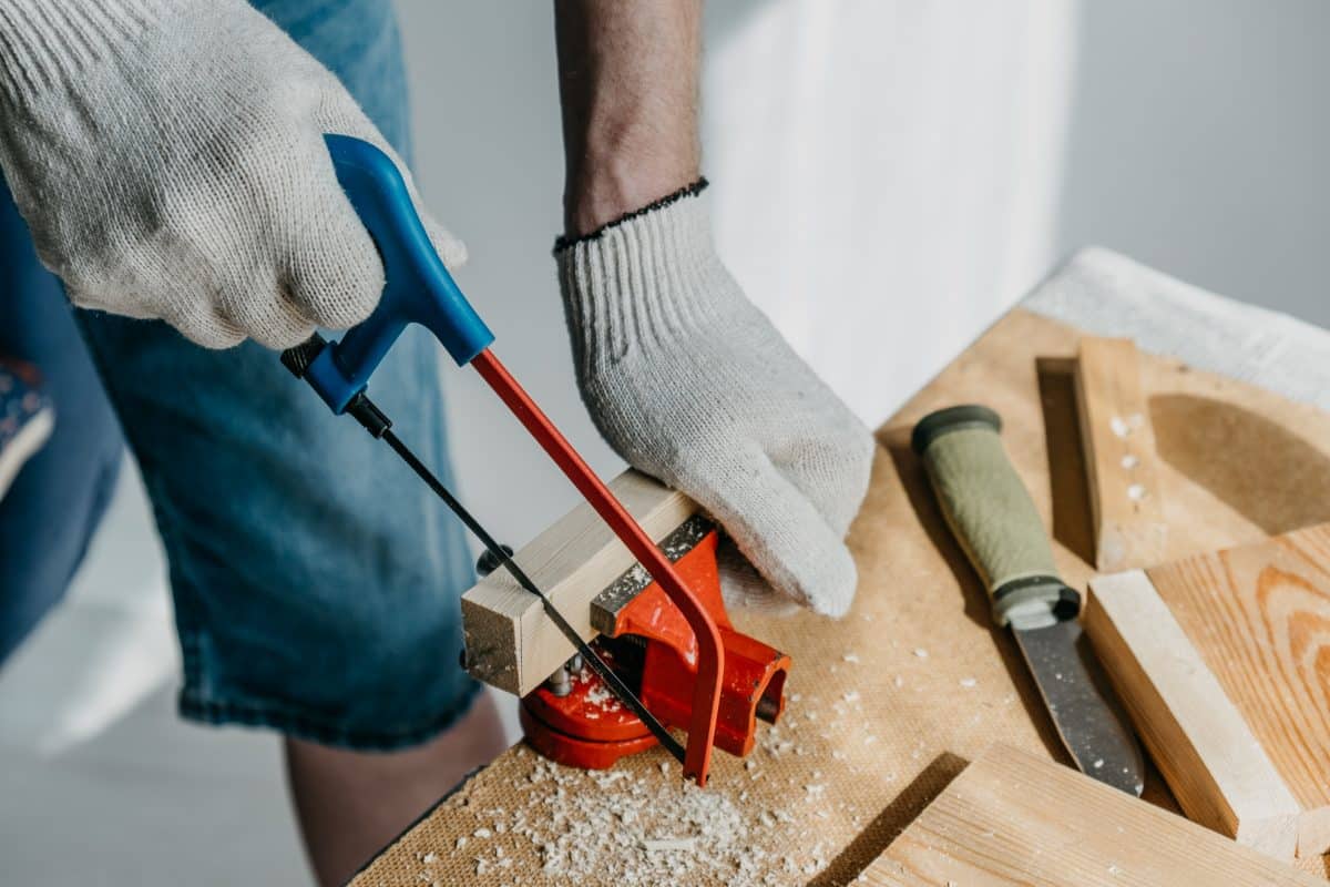 Ein Handwerker sägt ein Holzstück.