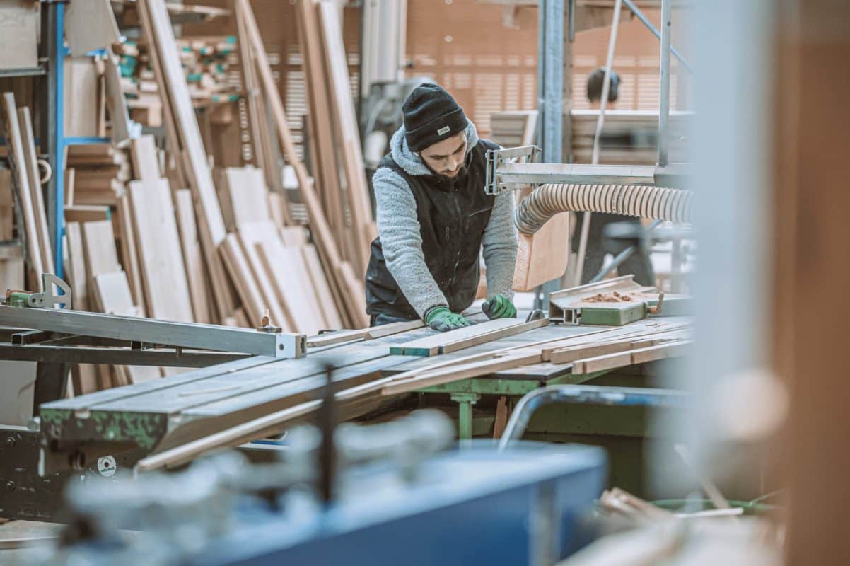 In der Werkstatt werden lange Holzleisten sorgfältig vermessen und für die Weiterverarbeitung vorbereitet.