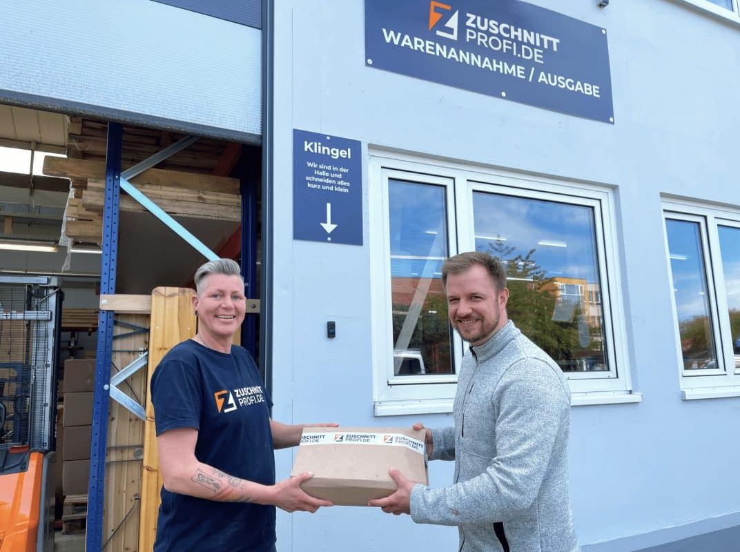 Vor dem Wareneingang wechselt ein Paket den Besitzer, begleitet von einem freundlichen Austausch.