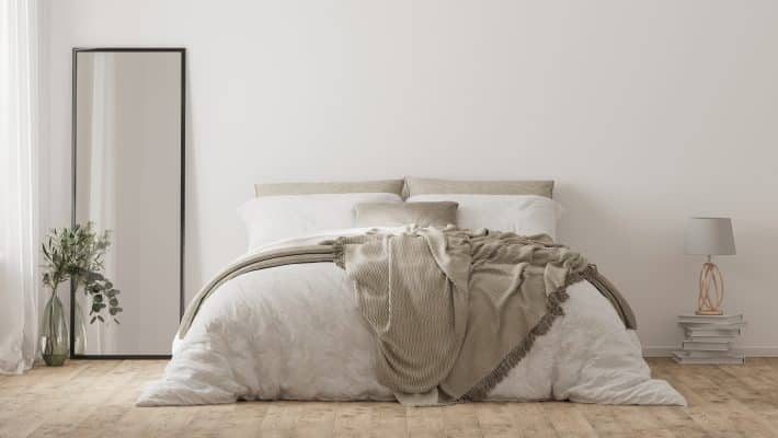 Minimalistisches Schlafzimmer mit großem Standspiegel und Bett.