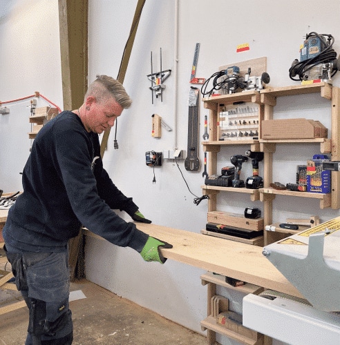 Ein Holzbrett wird sorgfältig auf der Werkbank ausgerichtet und für die weitere Bearbeitung vorbereitet.