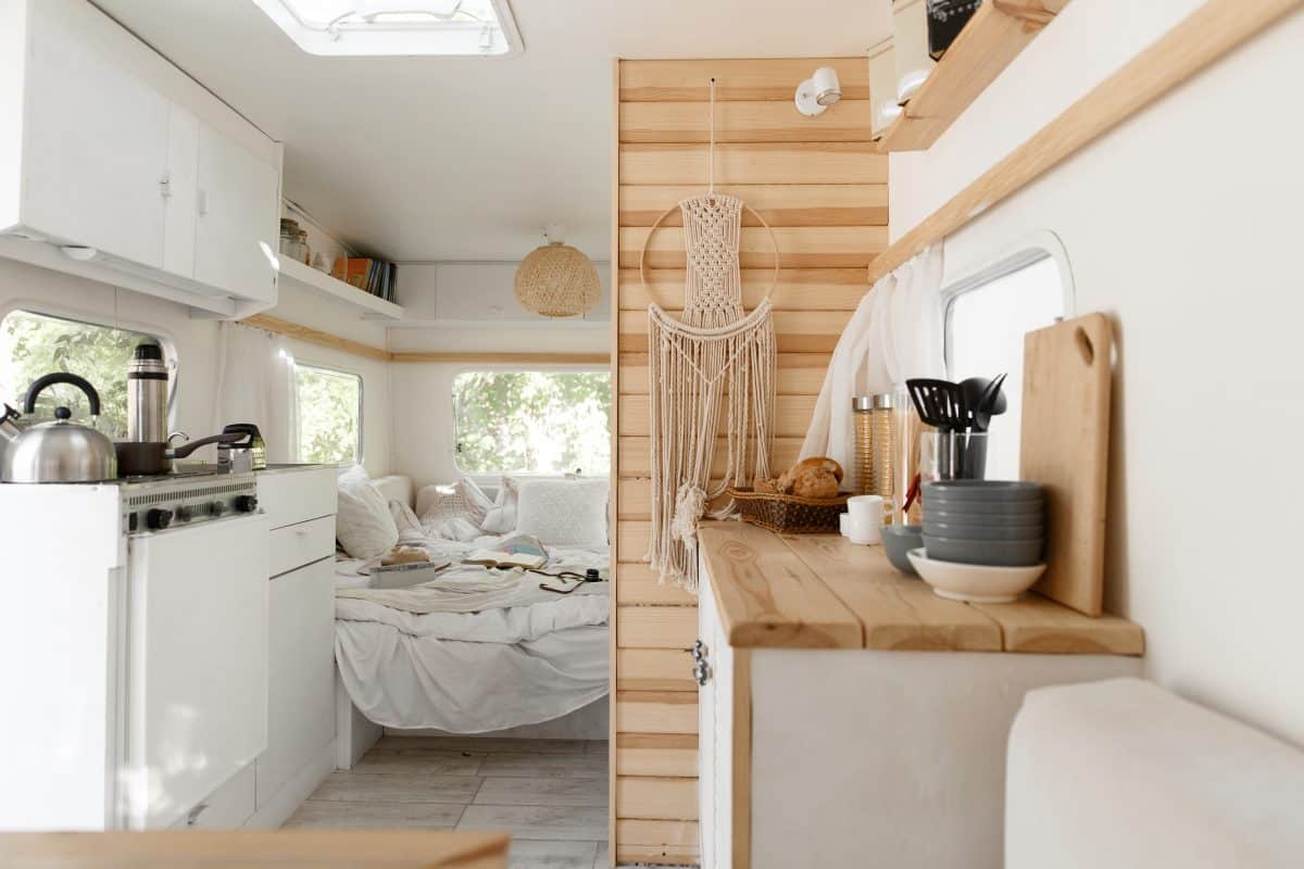 Gemütlich ausgebauter Camper mit Küche, Holzelementen und Schlafbereich.