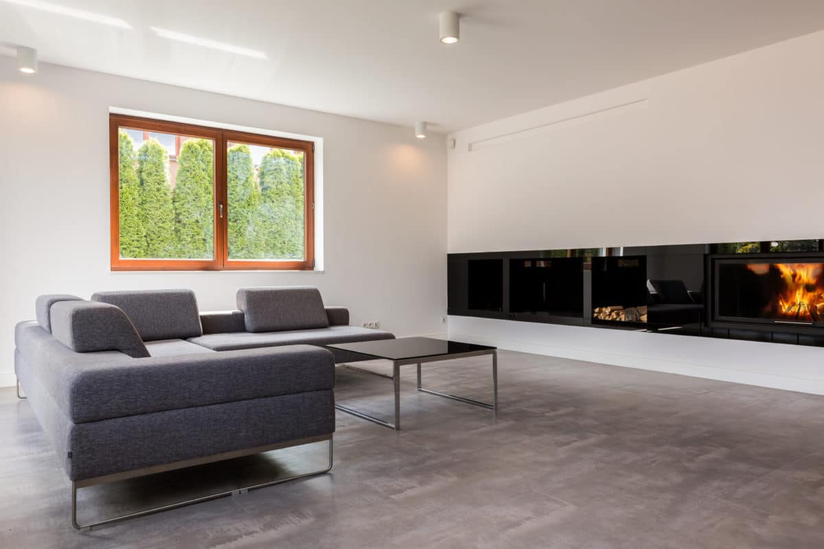 Moderner, schwarzfarbiger in die Länge gezogener Kamin im Wohnzimmer.
