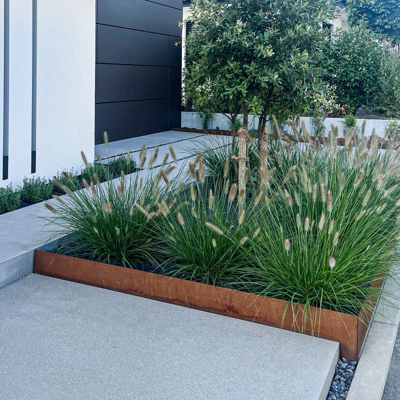 Cortenstahl-Elemente im Garten mit natürlicher Rostpatina, ideal für dekorative und funktionale Gartengestaltung.