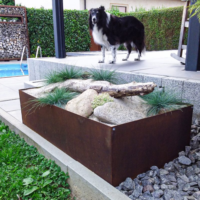 Cortenstahl-Elemente im Garten mit natürlicher Rostpatina, ideal für dekorative und funktionale Gestaltung.