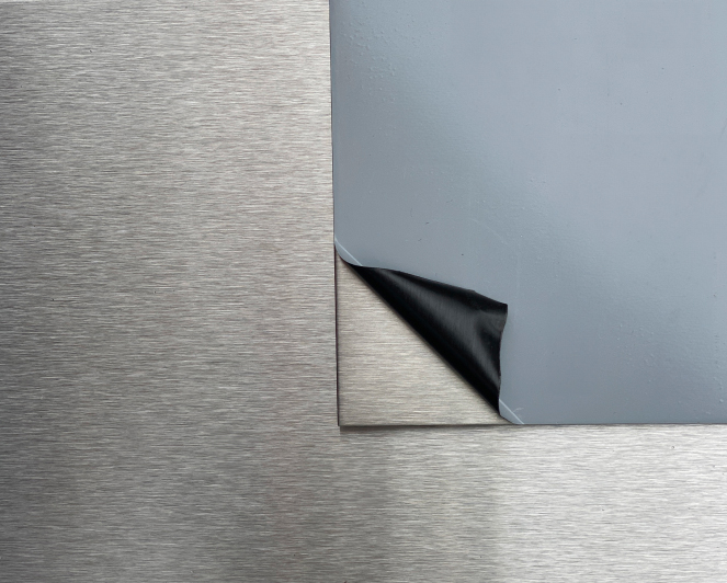 Edelstahlblech mit blauer Schutzfolie in Detailaufnahme, Oberfläche geschützt vor Kratzern und Beschädigungen.