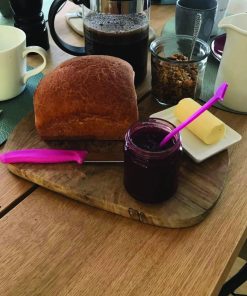 Frühstückstisch aus Eiche mit Brot, Marmelade, Kaffee und frischer Butter.