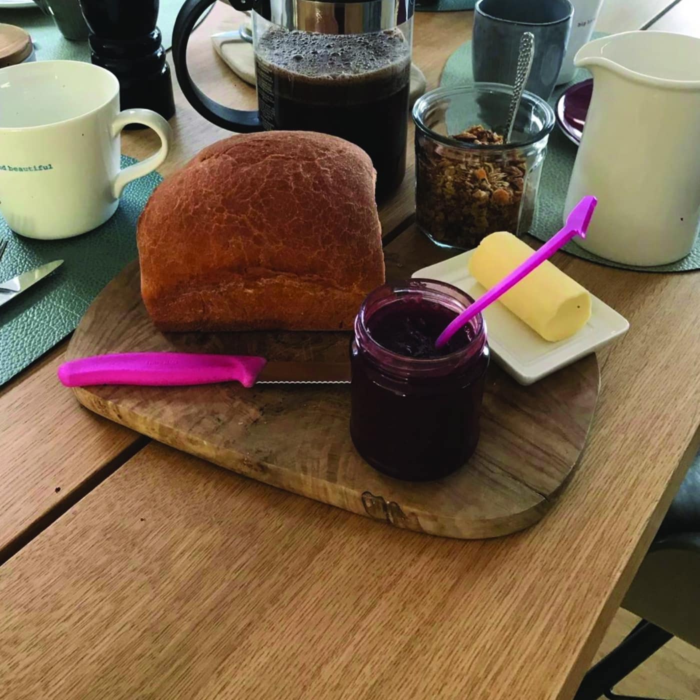 Frühstückstisch aus Eiche mit Brot, Marmelade, Kaffee und frischer Butter.
