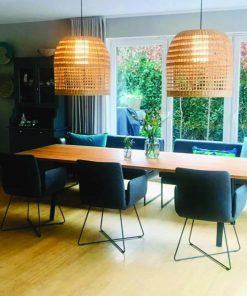 Essbereich mit großem Eichenholztisch, Rattanlampen und modernem, hellen Interieur.