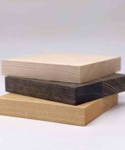 Drei Esche Holzplatten liegen gestapelt und zeigen verschiedene Farbtöne und Strukturen.