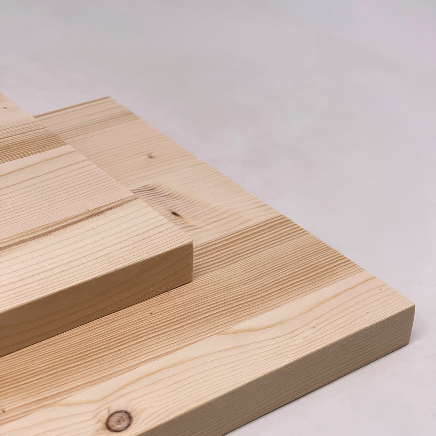 Zwei Fichten Platten liegen übereinander und zeigen eine natürliche Holzstruktur.