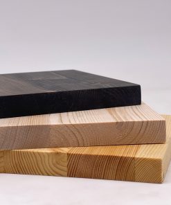 Mehrere Fichtenholz-Platten liegen gestapelt und zeigen helle und dunkle Farbtöne.