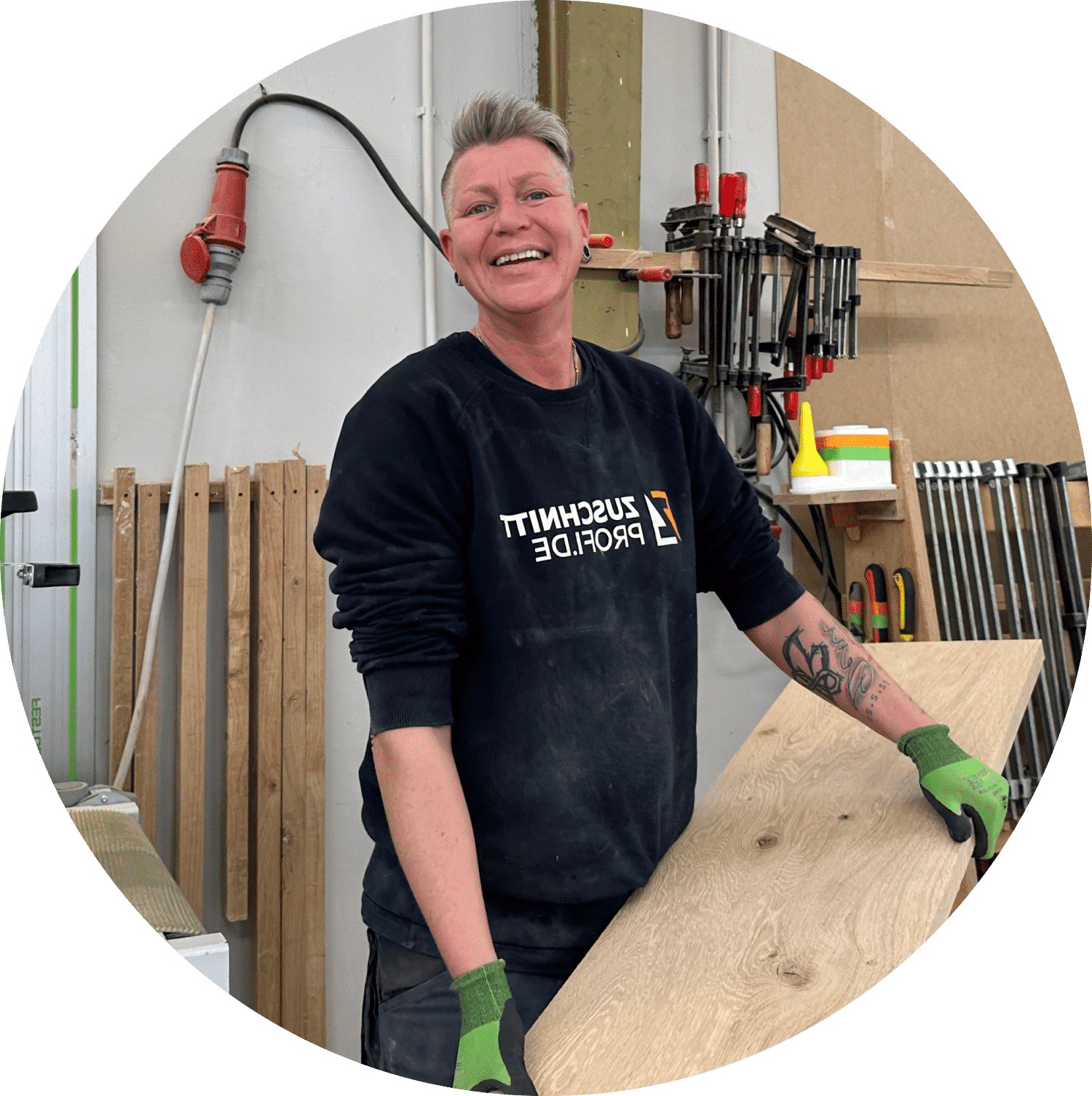 Eine Mitarbeiterin bearbeitet Holzplatten präzise in der Werkstatt.